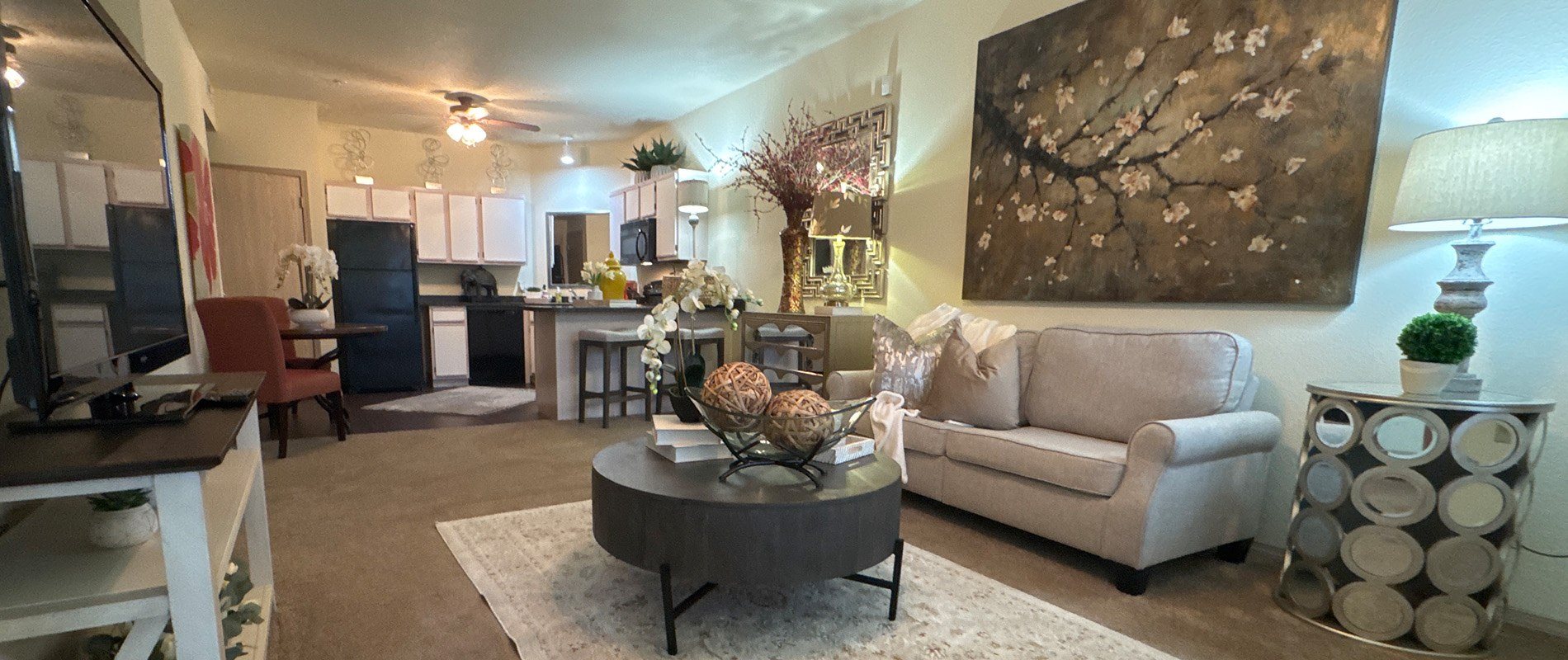 A living room with a large painting on the wall and a coffee table in the center.